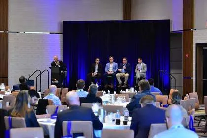Panel session viewed from back of ballroom at Tech Valley Cybersecurity Symposium